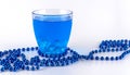 Blue liquid in a glass with ice on a white background