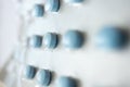 Blue little round pills with selective focus, macro. Close-up medicine tablets packed in blister