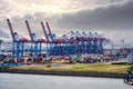 Blue loading cranes with red cabins in container port for unloading cargo from container ships Royalty Free Stock Photo
