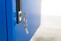 Blue locker and key chain in school gym. Modern metal cabinets and copyspace for your design