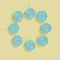 Blue lollipop candies in circle on pastel yellow background