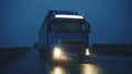 Blue Long Haul Semi-Truck with Cargo Trailer Full of Goods Travels At Night on the Freeway Road Royalty Free Stock Photo