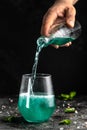 Blue low alcohol drink, chilled colorful beverages on rustic black background. summer party. Alcoholic drink concept. Freeze