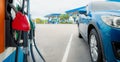 Blue luxury SUV car fueling at gas station. Refuel fill up with petrol gasoline. Petrol pump filling fuel nozzle in gas station. Royalty Free Stock Photo