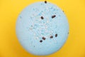 Blue macaron with coconut shavings and chocolate on yellow backgroundn Royalty Free Stock Photo