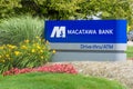 Blue Macatawa Bank Sign with drive thru, atm and flowers on green grass and blue sky Royalty Free Stock Photo