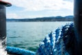 Blue marine rope on ship with lake water and landscape Royalty Free Stock Photo