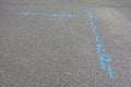 Blue markings on an asphalt street that show where the utility lines are berried so that they can be avoided if the road is dug up