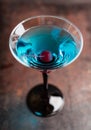 Blue martini cocktail with cherry on the rustic background Royalty Free Stock Photo