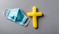 A blue mask and yellow cross on a table