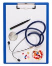 Blue medical clipboard with stethoscope and pills Royalty Free Stock Photo