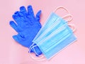 Blue medical gloves and disposable medical face mask isolated on pink background Royalty Free Stock Photo