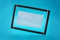 Blue medical mask in a black wooden frame, painting the year. Royalty Free Stock Photo