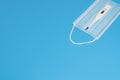 Blue medical mask and  electronic thermometr on blue background Royalty Free Stock Photo