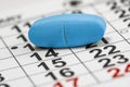 Blue medicine pill on the monthly calendar background