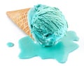 Blue melted ice cream in waffle cone on white background. Melt ice cream puddle near cone with ice Royalty Free Stock Photo