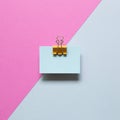 Blue memo paper, sticky notes with yellow binder clip on pink and blue background Royalty Free Stock Photo