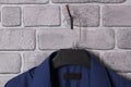 Blue mens shirt on brown plastic hanger on brick gray wall Royalty Free Stock Photo