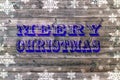 Blue Merry Christmas writen on wooden board with snoflake
