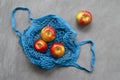 blue mesh eco zero waste shopping bag with fruit red apples, top view on ultimate gray background, close up with space Royalty Free Stock Photo