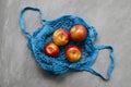 Blue mesh eco zero waste shopping bag with fruit red apples, top view on ultimate gray background, close up with space for text Royalty Free Stock Photo