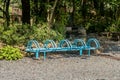 Blue metal bike rack in gravel lot in recreational forest park Royalty Free Stock Photo