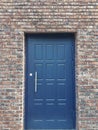 Blue metal door in a red brick wall. Royalty Free Stock Photo