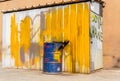 Blue metal drum in front of a shed painted in white and yellow. Text on the door: Dye house Royalty Free Stock Photo