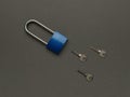 Blue metal lock and three keys on a dark gray background Royalty Free Stock Photo