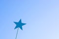 Blue metal star on a stick against the sky