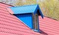 Blue metal tile roof with a window in the form of a house Royalty Free Stock Photo