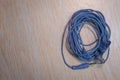 Audio Mini Jack Cable for microphone isolated on wooden background . Blue Microphone and headphone splitter cable