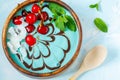Blue mint-chocolate smoothie bowl with cherry and coconut.