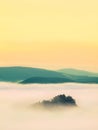 Blue misty morning, view over rock to deep valley full of light mist. Dreamy spring landscape within daybreak Royalty Free Stock Photo