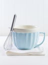 Blue mixing bowl with wisp for baking on white background