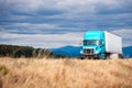 Blue modern big rig semi truck transport semi trailer on scenic Royalty Free Stock Photo
