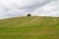 Blue modern tractor pulling a crop sprayer on a hill Royalty Free Stock Photo