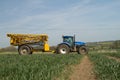 Blue modern tractor pulling a crop sprayer Royalty Free Stock Photo