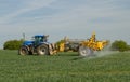 Blue modern tractor pulling a crop sprayer Royalty Free Stock Photo