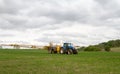 Blue modern tractor pulling a crop sprayer Royalty Free Stock Photo