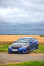 Blue modified car in field Royalty Free Stock Photo