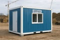 Blue Modular container office at construction site with open sky and earth mounds. concept of temporary office, construction Royalty Free Stock Photo