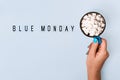 Blue monday text and female hand holds blue mug with cocoa on blue background. Blue monday concept