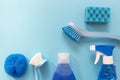 Blue monochrome flay lay of cleaning tool set with copy space in the left corner. Brushes, spray, bottles,