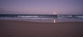 Blue Moon Rising over the Ocean with Surf and Sand Royalty Free Stock Photo