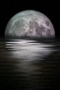 Blue moon rising out of the sea Royalty Free Stock Photo