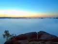 Blue morning, view over rock and fresh green trees to deep valley full of light mist. Dreamy spring landscape within daybreak Royalty Free Stock Photo