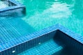 Blue mosaic tile steps in green swimming pool Royalty Free Stock Photo