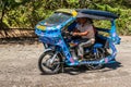 Blue motor-tricycle taxi on the move in Puerto Princesa, Palawan, Philippines