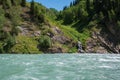 Blue mountain river with small waterfall influent to it. Koksu river in Dzungarian Alatau